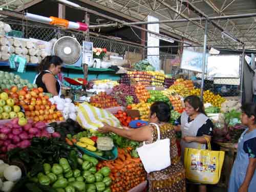 Escena cotidiana en el mercado de Puerto Escondido, Oaxaca México. Cuando se efectúa una tarnsacción, se revelan dos funciones al observador: lo que valora el comprador el prodducto y lo que le cuesta desprenderse de ese producto al vendedor.